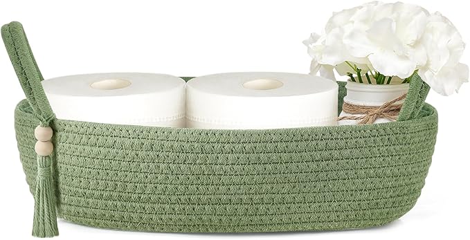 Green woven storage basket with handles holding toilet paper rolls