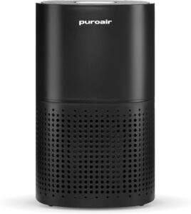 Black PuroAir air purifier with a cylindrical design, smooth upper housing, and perforated lower intake vents on a light background