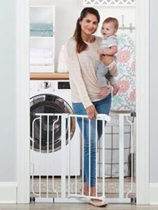 Mother holding baby next to white safety gate installed in doorway